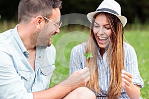 Smiling happy young couple spending time together on a picnic in park