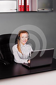 Smiling helpline operator with headphones