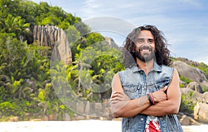 Smiling hippie man in denim vest on island beach