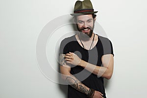Smiling Hipster boy. handsome man in hat. Brutal bearded boy with tattoo
