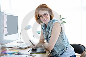 smiling hipster businesswoman writing on a digital tablet