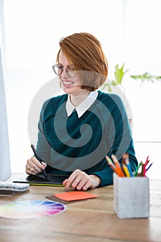 smiling hipster designer writing on a digital tablet