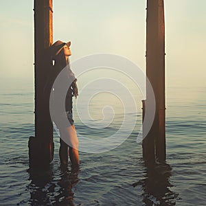 Smiling hipster girl walking on a sea beach.