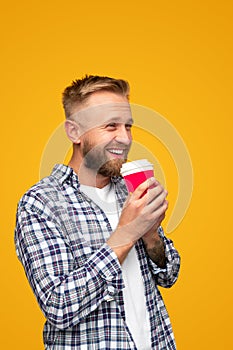 Smiling hipster having coffee to go