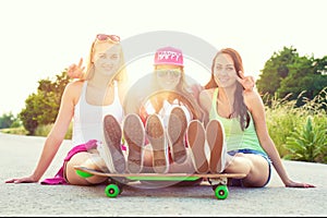 Smiling hipster teenage friends with skateboard, colorised image with sunflare