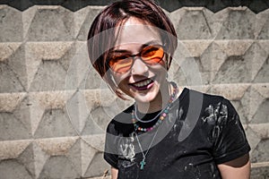 Smiling hipster woman in red glasses and dirty t-shirt