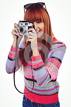 Smiling hipster woman taking pictures with a retro camera