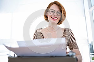 smiling hipster woman typing on her typewriter