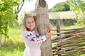 Smiling hirl standing near wooden fence