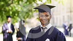 Smiling Hispanic graduate student rejoicing diploma, success, posing for camera