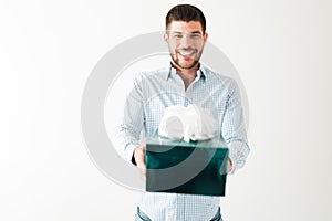 Smiling hispanic man is giving a present to someone