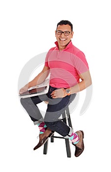 Smiling Hispanic man sitting on chair.