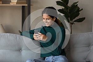 Smiling hispanic woman use smartphone browsing internet