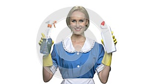 Smiling house maid showing cleaning products.