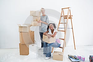 Smiling housemates carrying cardboard moving boxes