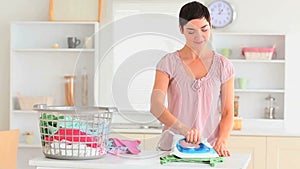 Smiling housewife ironing clothes
