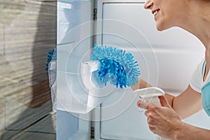 Smiling housewife making refrigerator clean