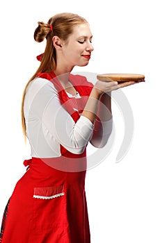 Smiling housewife in red apron with funny ponytails and wooden c