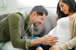 Smiling husband and wife thrilled for their new baby