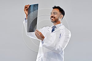 Smiling indian doctor looking at spine x-ray