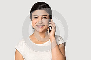 Smiling indian girl look at camera talking on cell