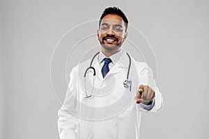 Smiling indian male doctor pointing finger to you