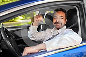 smiling indian man or driver showing car key