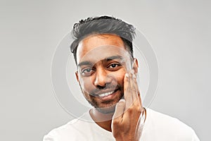 Smiling indian man touching his beard