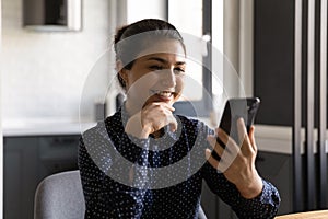 Smiling Indian woman read pleasant news on cell