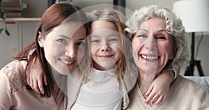Smiling intergenerational women family embracing bonding together, portrait