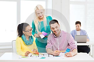 Smiling interior designers working in office