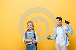 Smiling interracial schoolkids holding books 