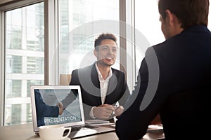 Smiling investment broker showing presentation on laptop screen