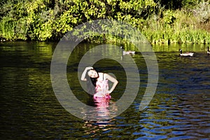 Smiling Japanese American Woman Standing In River With Geese