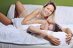 Smiling and joyful couple joking in bed