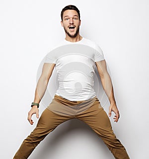 Smiling joyful man jumping on a white background.