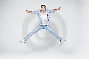 Smiling joyful man jumping on white background.