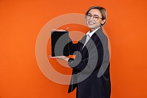 Smiling joyful woman wearing black official style suit showing empty screen of tablet