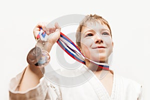 Smiling karate champion child boy gesturing for victory triumph