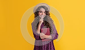 smiling kid with frizz hair read book on yellow background