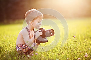 Smiling kid holding a DSLR camera in park