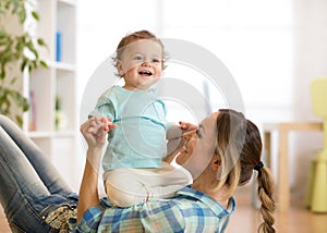 Smiling kid and mom having a fun pastime on floor in children room at home