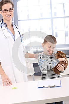 Smiling kid with pet rabbit at veterinary