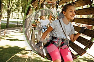 Smiling kids climbs in rope park, playground