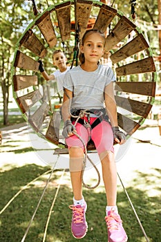 Smiling kids climbs in rope park, playground