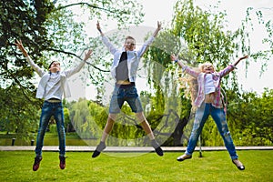 Smiling kids having fun and jumping at grass. Children playing outdoors in summer. teenagers communicate outdoor