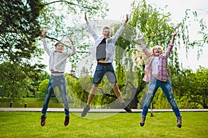 Smiling kids having fun and jumping at grass. Children playing outdoors in summer. teenagers communicate outdoor