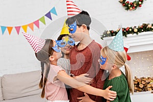 Smiling kids hugging asian friend in