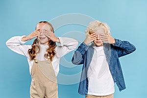 smiling kids obscuring faces with hands