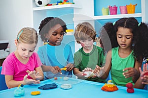 Smiling kids playing with modelling clay